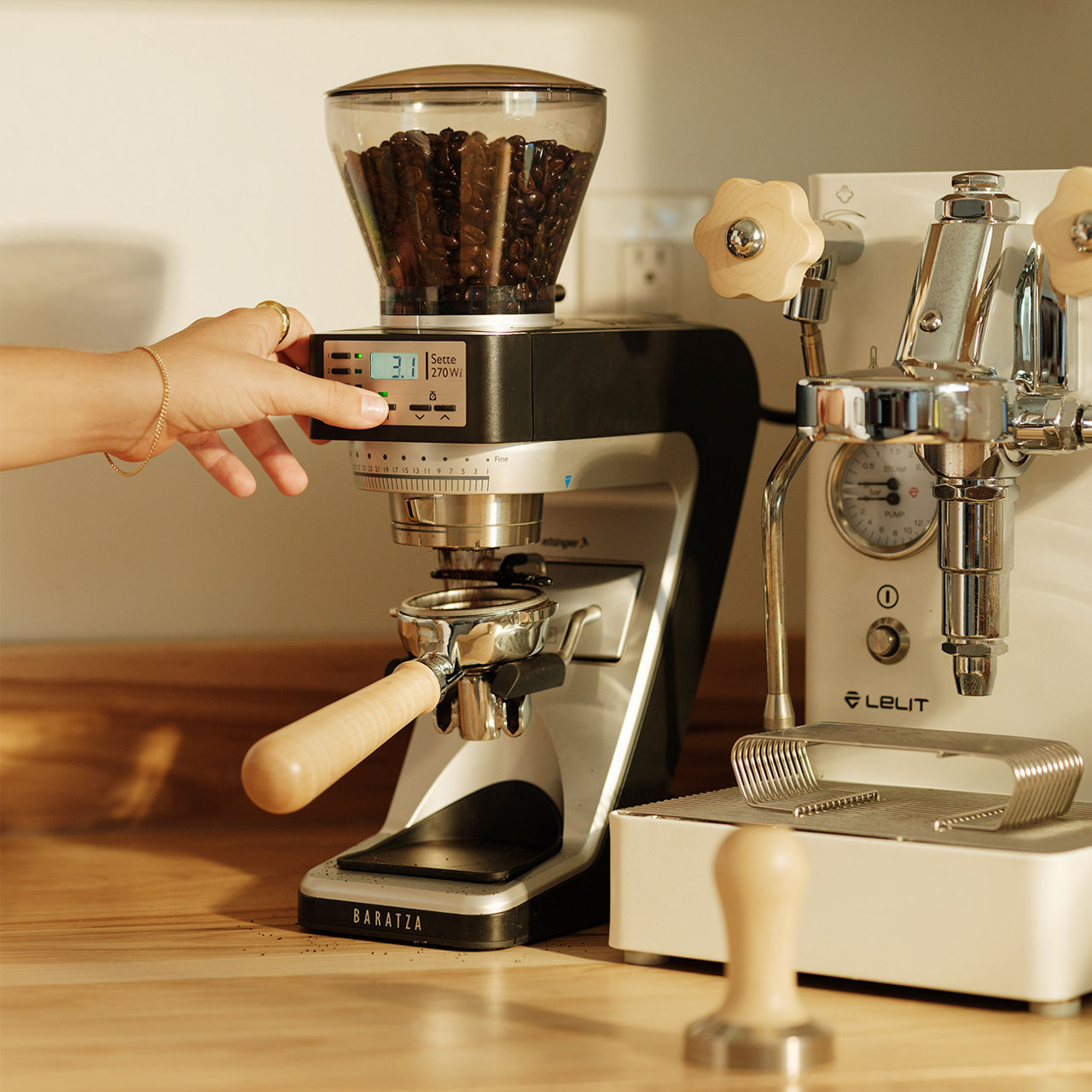 White Baratza grinder next to several Christmas tree ornaments.